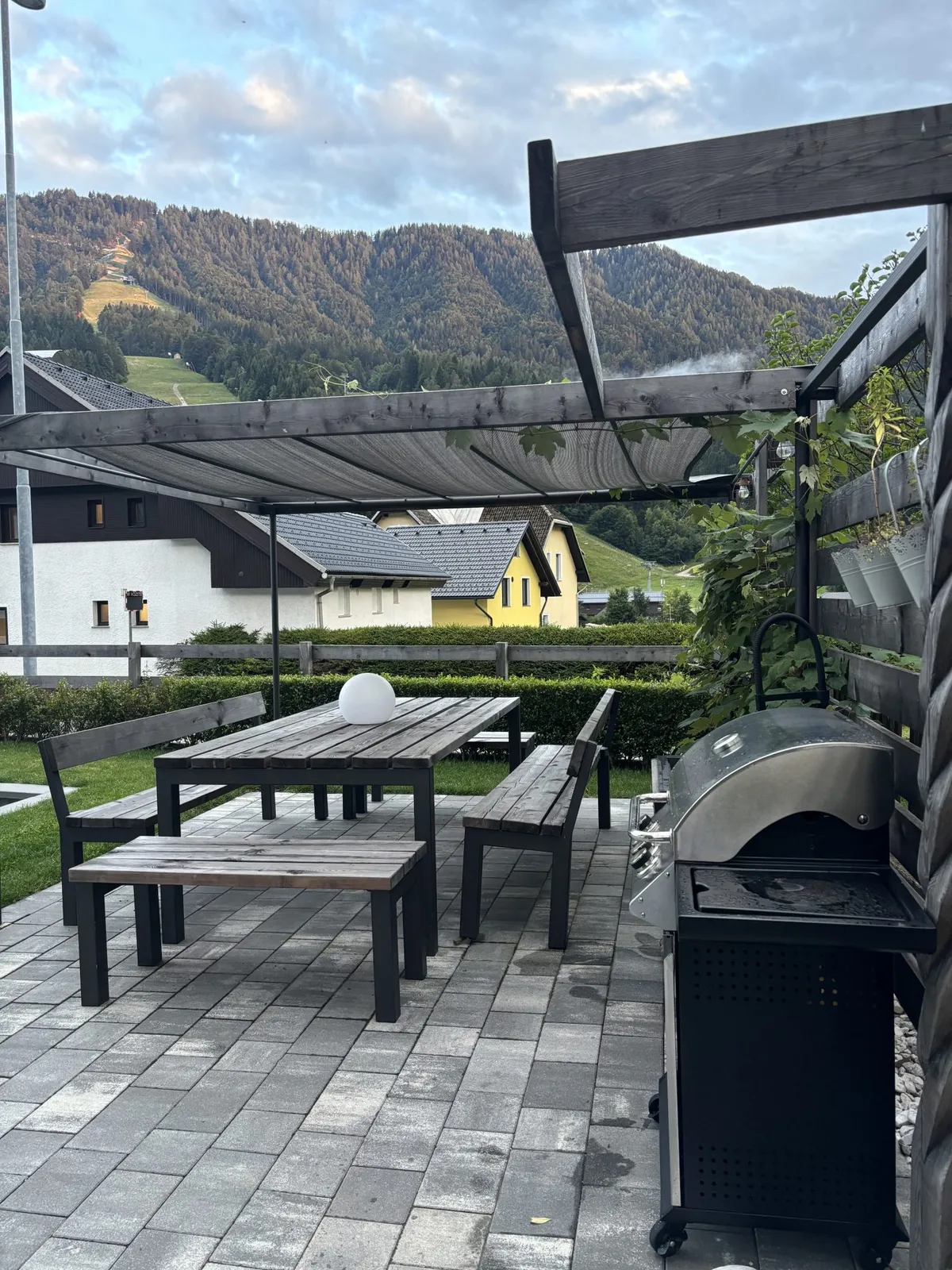 Pergola z mizo, klopmi in plinskim žarom na vrtu